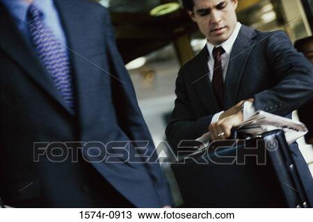 Stock Image - Businessman looking at his wristwatch. Fotosearch