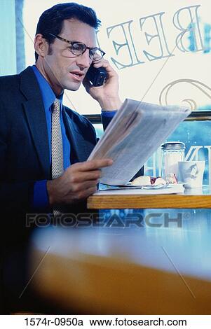 Businessman sitting in a cafe talking on a mobile phone View Large Photo Image Stock Image - Businessman sitting in a cafe talking on a mobile phone. Fotosearch