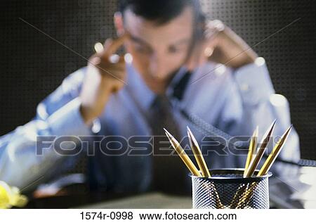 Stock Photo - Businessman talking on a landline telephone on the desk. Fotosearch