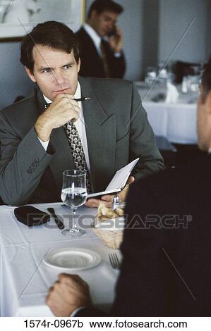 Businessmen discussing in a restaurant View Large Photo Image Stock Image - Businessmen discussing in a restaurant. Fotosearch