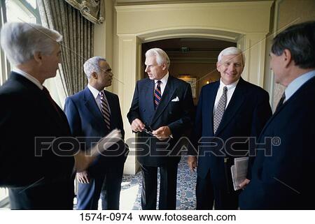 Picture - Businessmen talking in a corridor. Fotosearch