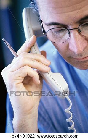 Stock Image - Close-up of a businessman using a landline telephone. Fotosearch