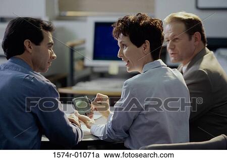 Stock Image - Rear view of business executives in a meeting. Fotosearch