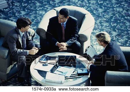 Stock Image - Three business executives having a discussion. Fotosearch