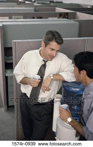 Two business executives talking at a water cooler View Large Photo Image Stock Photo - Two business executives talking at a water cooler. Fotosearch