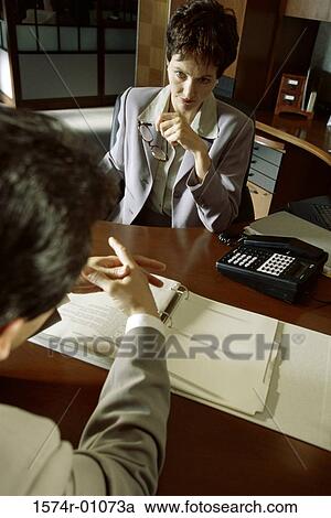 Stock Image - Two business executives talking in an office. Fotosearch