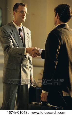Stock Image - Two businessmen shaking hands. Fotosearch