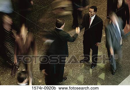 Stock Image - Two businessmen shaking hands. Fotosearch