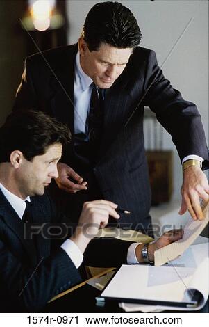 Stock Image - Two businessmen sitting and talking in a meeting. Fotosearch