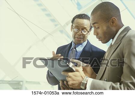 Stock Image - Two businessmen talking to each other. Fotosearch