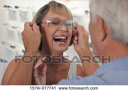 Close-up of a senior man putting sunglasses on a senior woman in a store View Large Photo Image Stock Image - Close-up of a senior man putting sunglasses on a senior woman in a store. Fotosearch