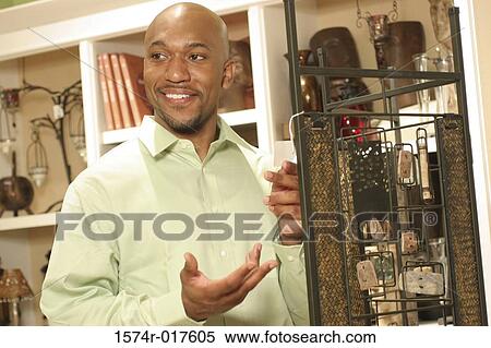Close-up of a young man smiling near a metal rack in a store View Large Photo Image Stock Photography - Close-up of a young man smiling near a metal rack in a store. Fotosearch