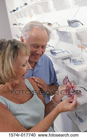 High angle view of a senior couple selecting sunglasses in a store View Large Photo Image Stock Image - High angle view of a senior couple selecting sunglasses in a store. Fotosearch