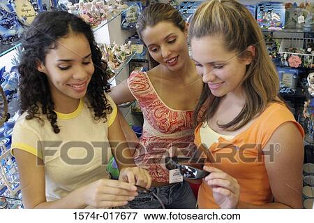 High angle view of three young women selecting sunglasses in a store View Large Photo Image Stock Photo - High angle view of three young women selecting sunglasses in a store. Fotosearch