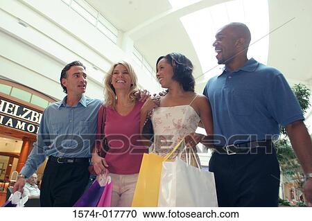 Low angle view of two young couples carrying shopping bags View Large Photo Image Stock Image - Low angle view of two young couples carrying shopping bags. Fotosearch