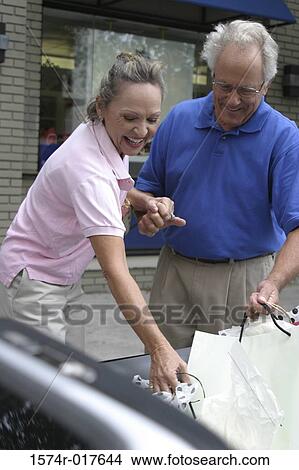 Senior couple putting shopping bags in their car View Large Photo Image Picture - Senior couple putting shopping bags in their car. Fotosearch