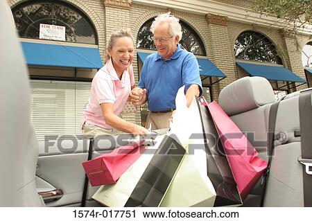 Senior couple putting shopping bags in their car View Large Photo Image Stock Image - Senior couple putting shopping bags in their car. Fotosearch