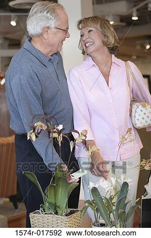 Stock Image - Senior couple standing in a furniture store. Fotosearch