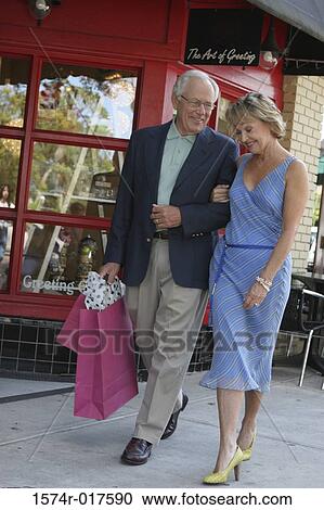 Senior couple walking with shopping bags View Large Photo Image Stock Image - Senior couple walking with shopping bags. Fotosearch