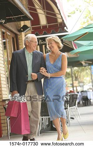 Senior couple walking with shopping bags View Large Photo Image Stock Image - Senior couple walking with shopping bags. Fotosearch