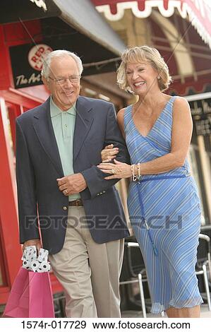 Senior couple walking with shopping bags View Large Photo Image Stock Photo - Senior couple walking with shopping bags. Fotosearch