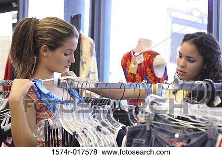 Side profile of two young women selecting clothes in a clothing store View Large Photo Image Stock Photo - Side profile of two young women selecting clothes in a clothing store. Fotosearch