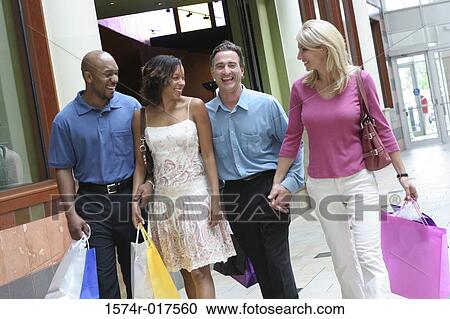 Two young couples carrying shopping bags View Large Photo Image Stock Image - Two young couples carrying shopping bags. Fotosearch