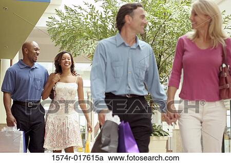 Two young couples carrying shopping bags View Large Photo Image Stock Image - Two young couples carrying shopping bags. Fotosearch