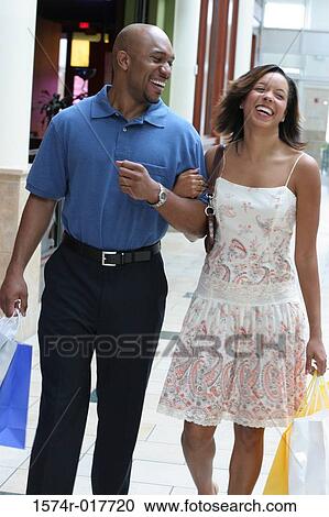 Stock Image - Young couple carrying shopping bags. Fotosearch