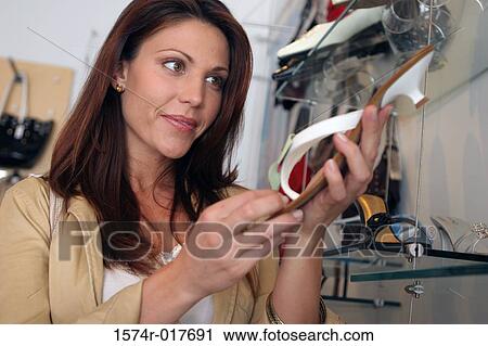 Young woman holding a sandal in a shoe store View Large Photo Image Stock Image - Young woman holding a sandal in a shoe store. Fotosearch