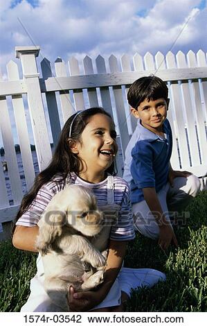 Boy and a girl playing with a puppy View Large Photo Image Stock Image - Boy and a girl playing with a puppy. Fotosearch