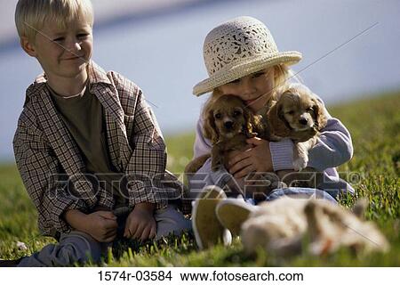 Boy and a girl sitting with puppies View Large Photo Image Picture - Boy and a girl sitting with puppies. Fotosearch