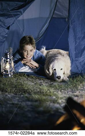 Boy camping in a tent with his dog View Large Photo Image Stock Image - Boy camping in a tent with his dog. Fotosearch