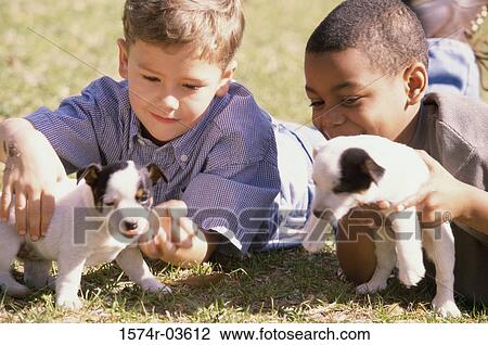 Close-up of two boys holding puppies View Large Photo Image Stock Image - Close-up of two boys holding puppies. Fotosearch