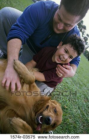 Father and his son playing with their dog View Large Photo Image Stock Photography - Father and his son playing with their dog. Fotosearch