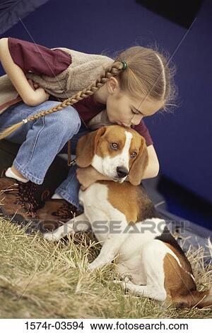 Girl kissing a dog on the forehead View Large Photo Image Picture - Girl kissing a dog on the forehead. Fotosearch