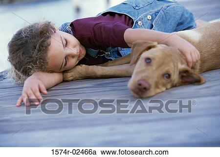 Girl lying down with her dog View Large Photo Image Stock Image - Girl lying down with her dog. Fotosearch