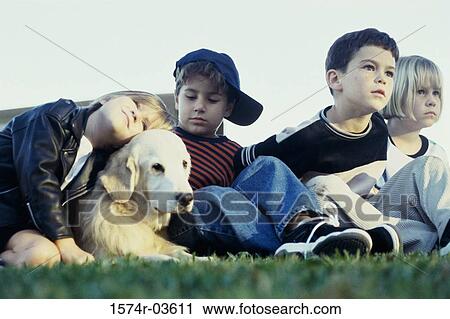 Stock Image - Group of children sitting with their dog. Fotosearch