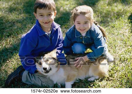 High angle view of a boy and a girl petting their dog View Large Photo Image Stock Image - High angle view of a boy and a girl petting their dog. Fotosearch