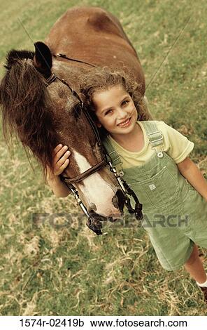 High angle view of a girl standing with a horse View Large Photo Image Stock Image - High angle view of a girl standing with a horse. Fotosearch