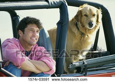 Mid adult man sitting in a jeep with his dog View Large Photo Image Stock Image - Mid adult man sitting in a jeep with his dog. Fotosearch