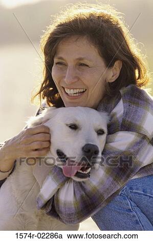 Mid adult woman hugging her dog View Large Photo Image Stock Image - Mid adult woman hugging her dog. Fotosearch