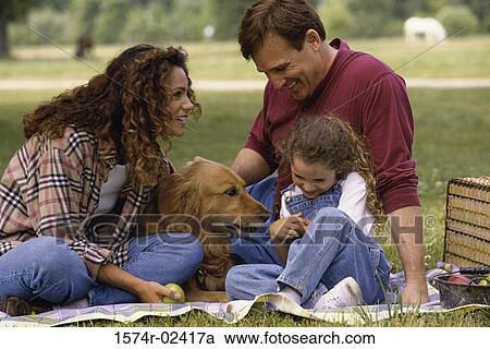 Stock Image - Parents with their daughter and a dog. Fotosearch