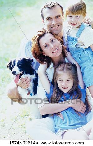Stock Image - Parents with their son and daughter holding a dog. Fotosearch
