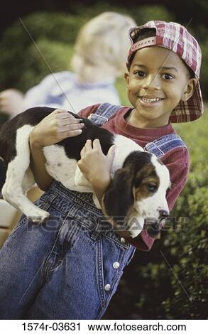 Portrait of a boy holding a puppy View Large Photo Image Stock Image - Portrait of a boy holding a puppy. Fotosearch