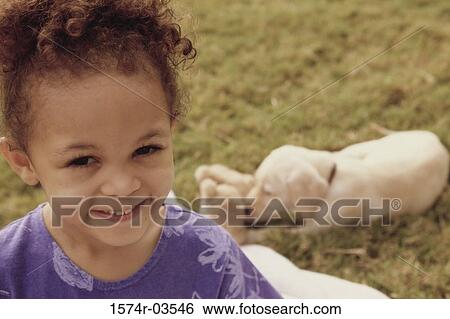 Stock Photograph - Portrait of a girl smiling with a puppy behind her. Fotosearch
