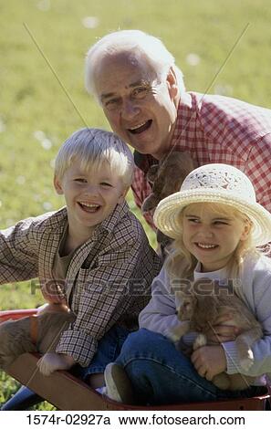 Portrait of a grandfather with his grandson and granddaughter holding puppies View Large Photo Image Stock Image - Portrait of a grandfather with his grandson and granddaughter holding puppies. Fotosearch