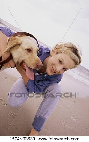 Portrait of a young woman with her dog on the beach View Large Photo Image Stock Image - Portrait of a young woman with her dog on the beach. Fotosearch