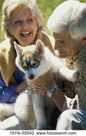 Senior couple holding their dog View Large Photo Image Stock Image - Senior couple holding their dog. Fotosearch