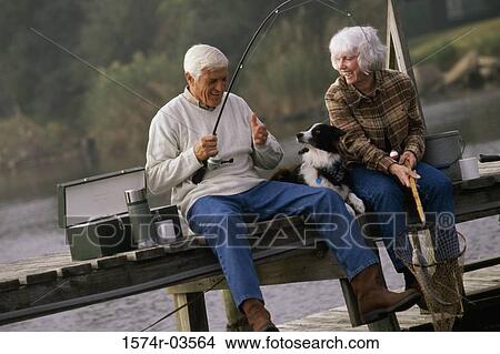 Senior couple sitting on a dock with their dog fishing View Large Photo Image Picture - Senior couple sitting on a dock with their dog fishing. Fotosearch